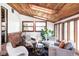 Inviting sunroom featuring comfortable seating, wood accents, and a cozy atmosphere at 6842 W Eldorado Pl, Lakewood, CO 80227