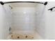 Tiled bathroom featuring a deep soaking tub, shower head, and modern fixtures at 942 S Walden St # 206, Aurora, CO 80017
