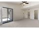Bright bedroom featuring neutral carpet, high ceilings with fan, and sliding glass door to outside area at 942 S Walden St # 206, Aurora, CO 80017