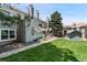 Charming condo exterior with a well-maintained lawn and mature trees under a clear blue sky at 942 S Walden St # 206, Aurora, CO 80017