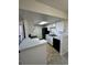 Galley kitchen with white cabinets, black appliances, and a breakfast bar at 942 S Walden St # 206, Aurora, CO 80017