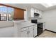 Updated kitchen showing white cabinets and black appliances open to living room at 942 S Walden St # 206, Aurora, CO 80017