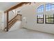 Bright open living room showcasing staircase, entry door, and multiple windows at 942 S Walden St # 206, Aurora, CO 80017