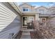 Front entrance with black rocking chairs, gray siding, and landscaped walkway at 7887 S Kittredge Cir, Englewood, CO 80112