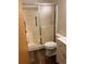 Bathroom featuring a walk-in shower with sliding glass door, white toilet and white sink at 9724 W Euclid Dr, Littleton, CO 80123
