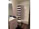 Clean bathroom with a single sink vanity, blue towels, and a shower/tub combo with striped curtain at 9724 W Euclid Dr, Littleton, CO 80123