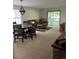 A spacious living room with carpet flooring, dining table and chairs, couch and sliding glass door to a deck at 9724 W Euclid Dr, Littleton, CO 80123
