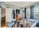 Bright bedroom with a large window, comfortable bed, and dresser with a wall-mounted TV at 925 N Lincoln St # 8E-S, Denver, CO 80203