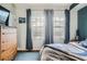 Bright bedroom with two windows and a dresser with a wall-mounted TV at 925 N Lincoln St # 8E-S, Denver, CO 80203