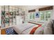 Bright bedroom featuring custom built-in bookshelves and large windows overlooking the backyard at 844 N Humboldt St # 5, Denver, CO 80218