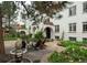 Charming white stucco home featuring arched doorways, a tile roof, a stone patio with a fountain, and colorful landscaping at 844 N Humboldt St # 5, Denver, CO 80218