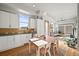 Modern kitchen and living room with white cabinetry, dining table and chairs, and plenty of sunlight at 2004 Foxtail Ln # B, Lafayette, CO 80026