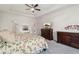 Bright bedroom with a ceiling fan, a large dresser, and neutral carpet creating a cozy atmosphere at 4564 N Picadilly Ct, Aurora, CO 80019