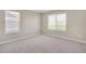Bright bedroom with neutral walls, plush carpet, and natural light from two large windows at 13477 Valentia St, Thornton, CO 80602