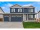Charming two-story home featuring a three-car garage, stone accents and a well-manicured lawn at 13477 Valentia St, Thornton, CO 80602