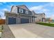 Charming two-story home featuring a three-car garage, stone accents and a well-manicured lawn at 13477 Valentia St, Thornton, CO 80602