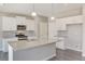 Contemporary kitchen with stainless appliances, granite counters, a center island, and ample storage at 13477 Valentia St, Thornton, CO 80602