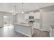 Open kitchen with a granite island, pendant lighting, stainless appliances and sliding glass doors at 13477 Valentia St, Thornton, CO 80602