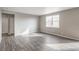 Inviting living room featuring natural light, neutral walls, and modern wood-look flooring at 13477 Valentia St, Thornton, CO 80602