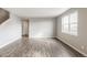 Bright, airy living room featuring gray-toned walls and wood-look flooring, perfect for modern living at 13477 Valentia St, Thornton, CO 80602