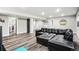 Open basement area featuring a large sectional sofa and durable flooring at 6227 Shenandoah Ave, Firestone, CO 80504