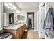 Bathroom with double vanity, tile floor, and large mirror at 6227 Shenandoah Ave, Firestone, CO 80504