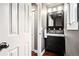 Stylish half bathroom with a modern vanity, sleek mirror, and fresh white towels at 6227 Shenandoah Ave, Firestone, CO 80504
