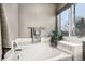 Bright bathroom featuring a large soaking tub and a plant next to a window at 6227 Shenandoah Ave, Firestone, CO 80504