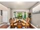 Dining room boasts a bright bay window, wood table, and decorative chairs at 6227 Shenandoah Ave, Firestone, CO 80504