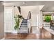 Bright foyer featuring hardwood floors, staircase with modern railings, and a view into the dining area at 6227 Shenandoah Ave, Firestone, CO 80504