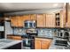 Kitchen close-up featuring granite countertops, stainless steel appliances, and wood cabinets at 6227 Shenandoah Ave, Firestone, CO 80504