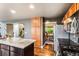 Open kitchen with stainless appliances, granite counters, and connection to the dining room and staircase at 6227 Shenandoah Ave, Firestone, CO 80504