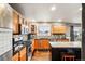 A spacious kitchen featuring stainless steel appliances, granite countertops, and wood cabinets at 6227 Shenandoah Ave, Firestone, CO 80504