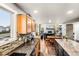 Open concept kitchen with granite countertops, wood cabinets, and stainless steel appliances at 6227 Shenandoah Ave, Firestone, CO 80504