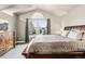 King bedroom with natural light, large window, dresser, and neutral decor at 6227 Shenandoah Ave, Firestone, CO 80504