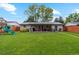 Spacious backyard with lush lawn, covered patio, and play equipment, perfect for outdoor activities at 806 S Jersey St, Denver, CO 80224