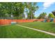 Expansive backyard with mature trees, lush green lawn, and various play structures at 806 S Jersey St, Denver, CO 80224