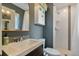 Well-lit bathroom with mosaic tile accents, shower, a gold-framed mirror, and gray walls at 806 S Jersey St, Denver, CO 80224