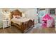 Charming bedroom featuring a wooden bed frame, neutral walls, and a playful pink tent at 806 S Jersey St, Denver, CO 80224