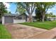 Quaint single-story home featuring a garage, driveway, and well-maintained lawn with mature trees at 806 S Jersey St, Denver, CO 80224