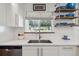 Modern kitchen featuring stainless steel appliances, white cabinetry, and a window offering natural light at 806 S Jersey St, Denver, CO 80224