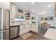 Modern white kitchen with stainless steel appliances and an adjacent dining area at 806 S Jersey St, Denver, CO 80224