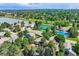 An aerial view of a neighborhood with a pond, tennis courts and swimming pool in a lush, green environment at 8845 W 81St Dr, Arvada, CO 80005