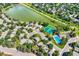 An overhead view of homes near a lake with community tennis courts and pool surrounded by verdant trees at 8845 W 81St Dr, Arvada, CO 80005