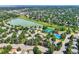 Expansive aerial view of a neighborhood highlighting the lake, tennis courts, pool, and tree-lined streets at 8845 W 81St Dr, Arvada, CO 80005