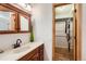 A bright bathroom offers wood cabinets and a spacious layout, leading into a walk-in closet for ample storage at 8845 W 81St Dr, Arvada, CO 80005