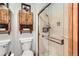 A bathroom features a shower with glass doors and wooden cabinets above the toilet for efficient storage solutions at 8845 W 81St Dr, Arvada, CO 80005