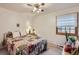 Bedroom with ceiling fan and light fixture over a colorful, patterned bed and a window with natural light at 8845 W 81St Dr, Arvada, CO 80005