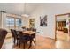 Bright dining room featuring a chandelier, hardwood floors, and a view into the adjacent kitchen at 8845 W 81St Dr, Arvada, CO 80005