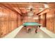 Basement game room with a ping pong table, wood paneled walls and ornate ceiling at 8845 W 81St Dr, Arvada, CO 80005